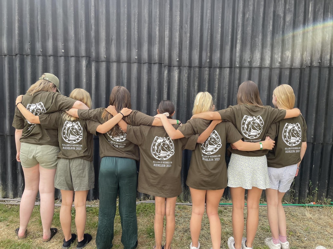 Ryttere i klubbens T-shirts med armene om hinanden